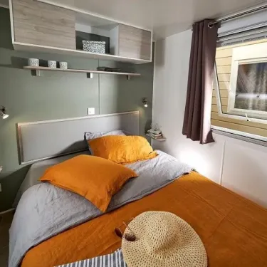 Mobil Home Grand Confort 3 Chambres TC - 6 Pers. - Domaine de L'Auzance : chambre avec lit et rideau