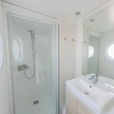 Mobil Home Confort+ 2 Chambres 4 Personnes et 1 Bébé - L'Écureuil : salle de bain avec douche et lavabo