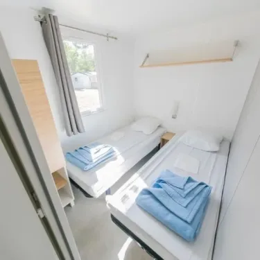 Mobil Home Confort+ 3 Chambres 6 Personnes - L'Écureuil : chambre avec 2 lits et rangement