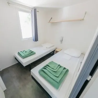 Chambre double avec lit simple et draps verts - Mobil Home Confort+ L'Écureuil