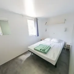 Chambre avec lit double et draps verts - Mobil Home Confort+ L'Écureuil