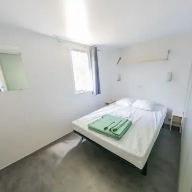 Chambre avec lit double et draps verts - Mobil Home Confort+ L'Écureuil