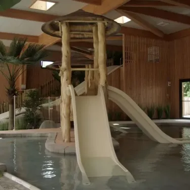 Piscine intérieure avec toboggan en bois au Camping Le Palace