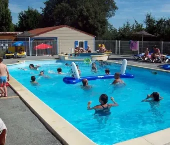 Enfants jouent au volley-ball dans la piscine du Camping Le Roc