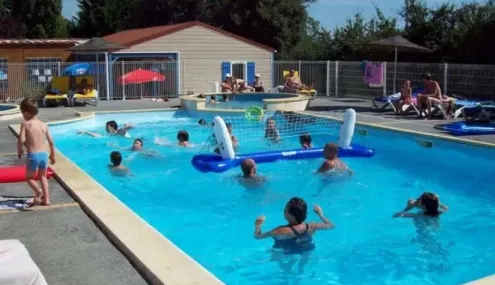 Enfants jouent au volley-ball dans la piscine du Camping Le Roc