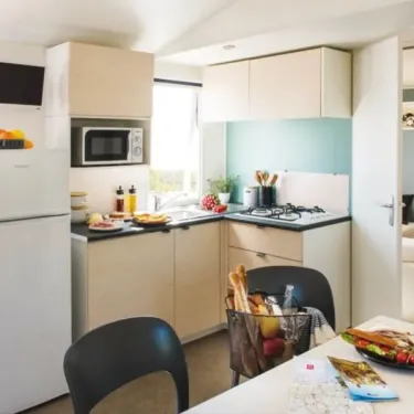 Cuisine équipée avec four, micro-ondes et table dans Mobil Home Aqua
