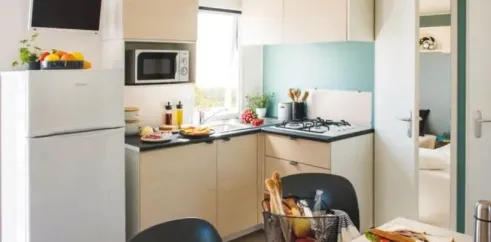 Cuisine équipée avec four, micro-ondes et table dans Mobil Home Aqua