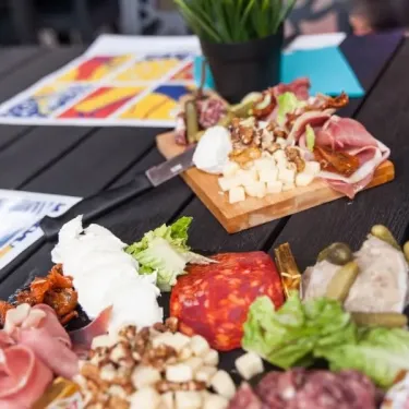 Camping Club Mahana - Platter de fromages et charcuteries sur table en bois