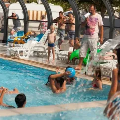 Camping Club Mahana : enfants et adultes jouent joyeusement autour d'une piscine avec un toboggan