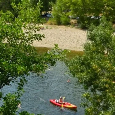 Un kayakiste navigue sur une rivière entourée de végétation dense.