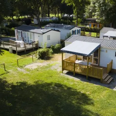 Camping Le Plantaurel : mobil-homes avec terrasses en bois entourés d'arbres