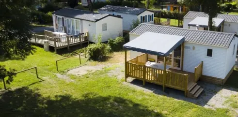 Camping Le Plantaurel : mobil-homes avec terrasses en bois entourés d'arbres