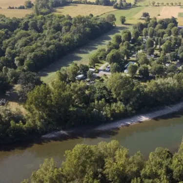 Vue aérienne du Camping Le Plantaurel bordant une rivière, entouré de forêt et de zones vertes.
