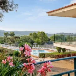 Vue depuis un balcon sur la piscine et les collines du Camping Le Parc des Chênes