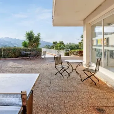Terrasse avec table et chaises, vue sur les collines, Camping Le Parc des Chênes