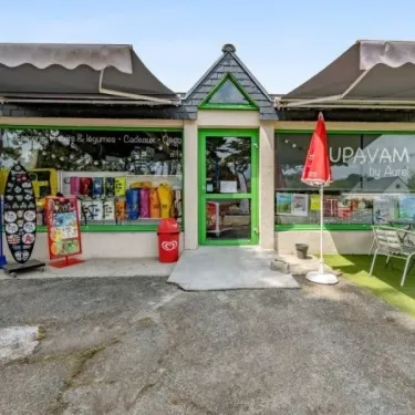 Magasin UPAVAM by Aurel au Camping Le Bois d'Amour - 29, vitrine avec produits et parasols.