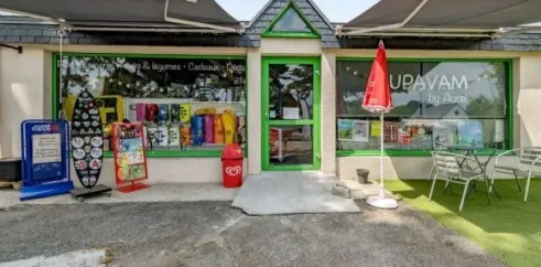 Magasin UPAVAM by Aurel au Camping Le Bois d'Amour - 29, vitrine avec produits et parasols.