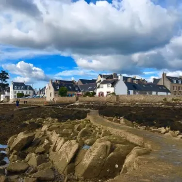 Village côtier avec maisons traditionnelles et rivière à marée basse