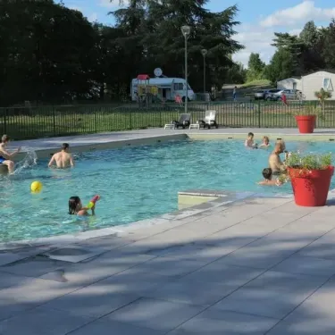Camping Chanset : enfants qui jouent dans la piscine avec un ballon jaune.