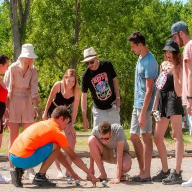 Groupe de personnes au Camping Aurilandes, jouant ensemble en plein air.