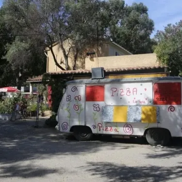 Camionnette pizza décorée devant Camping U Pezzo, sous arbres