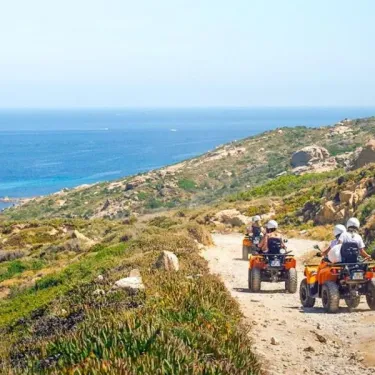 Quatre-roues motrices sur une route côtière à Camping U Pezzo, avec vue sur la mer.