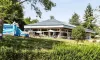 Camping Yaloer : bâtiment avec toboggan gonflable et parasols sur une pelouse verdoyante