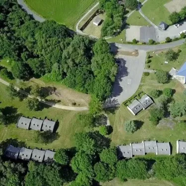 Vue aérienne du camping Yaloer avec des cabanes en rangées et une zone verte.