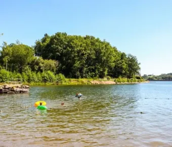 Camping Yaloer : personnes nageant dans un lac entouré de forêt