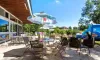 Camping Yaloer : terrasse extérieure avec tables, chaises et parasol bleu-vert
