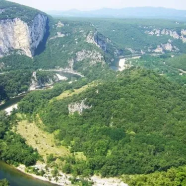 Camping Le Lion : vallée verdoyante avec un fleuve serpentant entre des falaises calcaires.