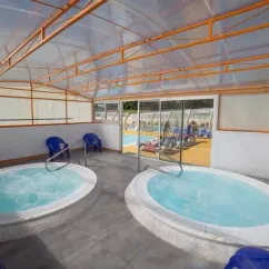 Deux jacuzzis sous une structure vitrée au Camping de La Plage - 29
