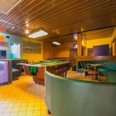 Photo du bar du camping La Plage avec billard et banquettes.
