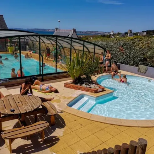 Piscine couverte avec enfants nageant, Camping Paradis - La Mer d'Iroise