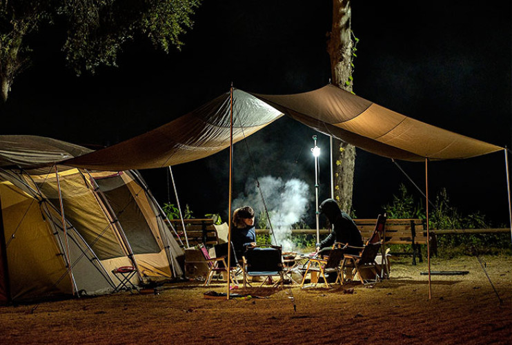 Petit Garçon Assis à L'intérieur D'une Tente Tipi Colorée à L'extérieur