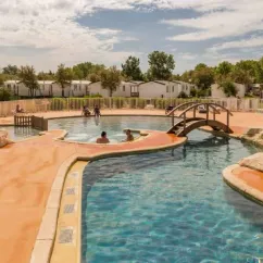 Piscine avec personnes se baignant et mobilhomes en arrière-plan au Camping Saint Maurice