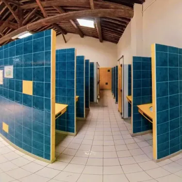 Salle de bain avec cabines bleues au Camping Saint Maurice
