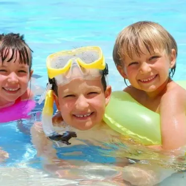 Enfants souriants dans la piscine avec masques de plongée au Camping La Riviera
