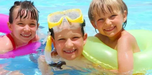 Enfants souriants dans la piscine avec masques de plongée au Camping La Riviera