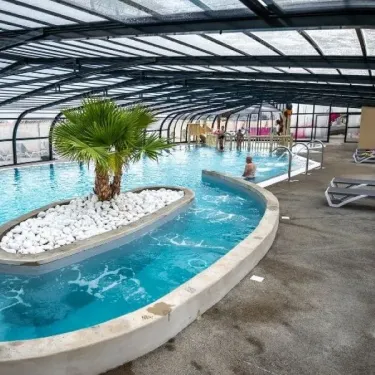 Piscine couverte avec palmier en milieu de bassin, Camping L'Océan