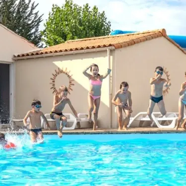 Enfants sautant dans la piscine extérieure, Camping L'Océan