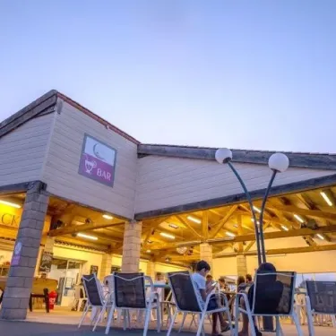 Camping L'Océan - Bar extérieur avec chaises et lampadaires