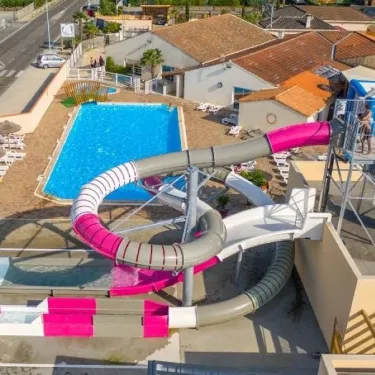 Vue aérienne d'une piscine avec toboggan rose et structure aquatique Camping L'Océan