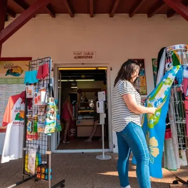 Camping Paradis - Biper Gorri : client choisissant un t-shirt dans la boutique