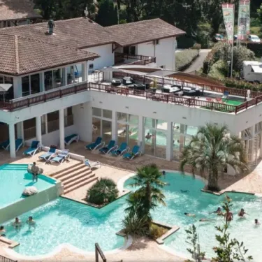 Piscine extérieure avec chaises longues et personnes nageant au Camping Paradis - Biper Gorri