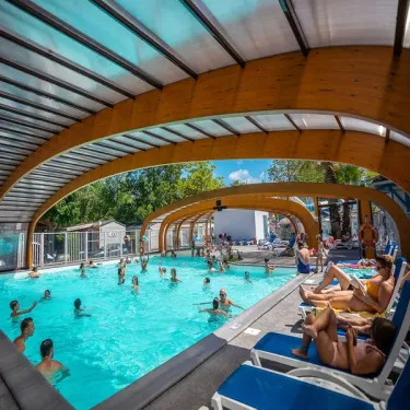 Piscine couverte avec personnes qui nagent au Camping Domaine de la Marina