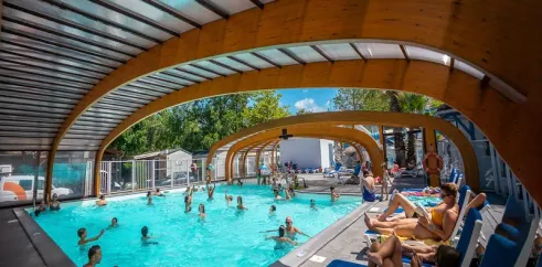 Piscine couverte avec personnes qui nagent au Camping Domaine de la Marina