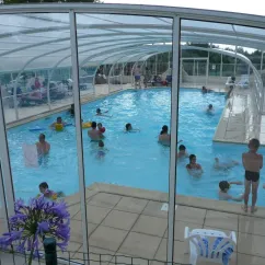 Piscine couverte avec enfants nageant au Camping Ker Vella