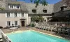 Piscine et piscine en plein air au Camping Le Clos de Banes, entourée d'une maison traditionnelle.