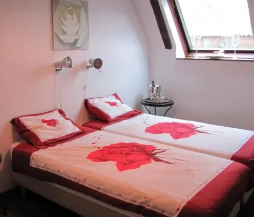 Chambre twin avec lits superposés et couvre-lits roses Le Clos de Banes